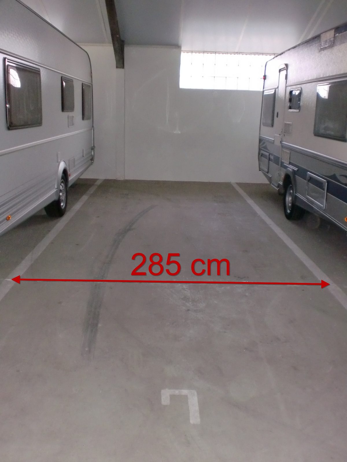 Innenansicht eines Hallenstellplatzes mit markierter Breite von 285 cm